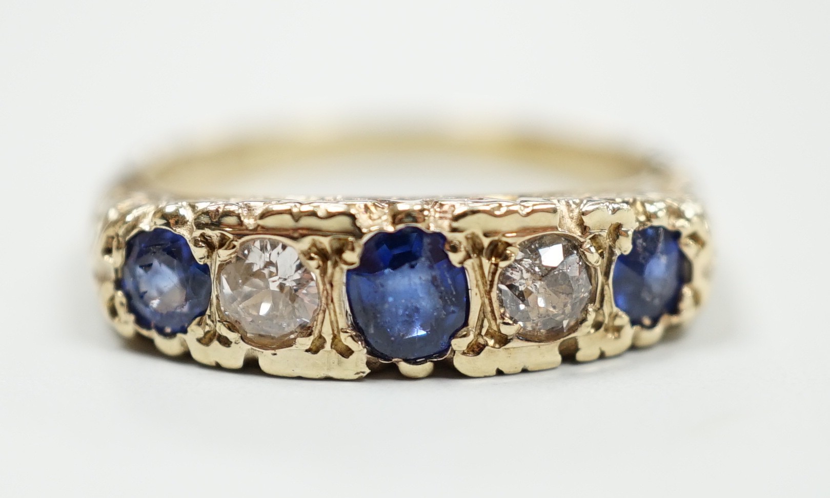 A modern Victorian style 9ct gold, three stone sapphire and two stone diamond set half hoop ring, size O, gross weight 4.3 grams.